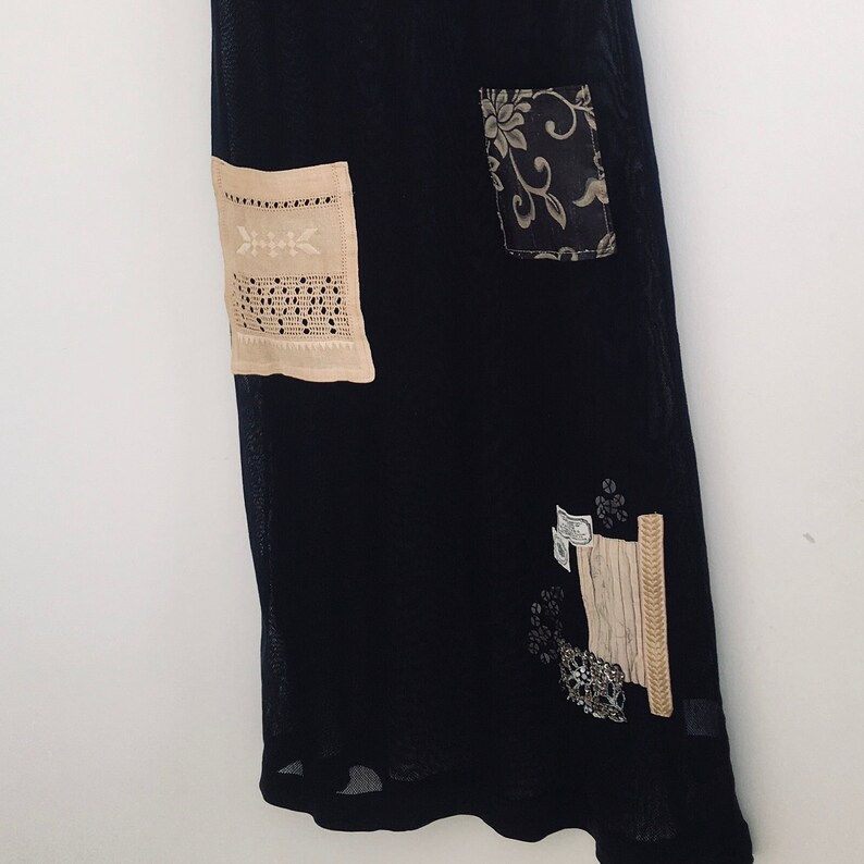 May include: A black mesh dress with various beige and brown fabric patches, including a floral design and a lace pattern.