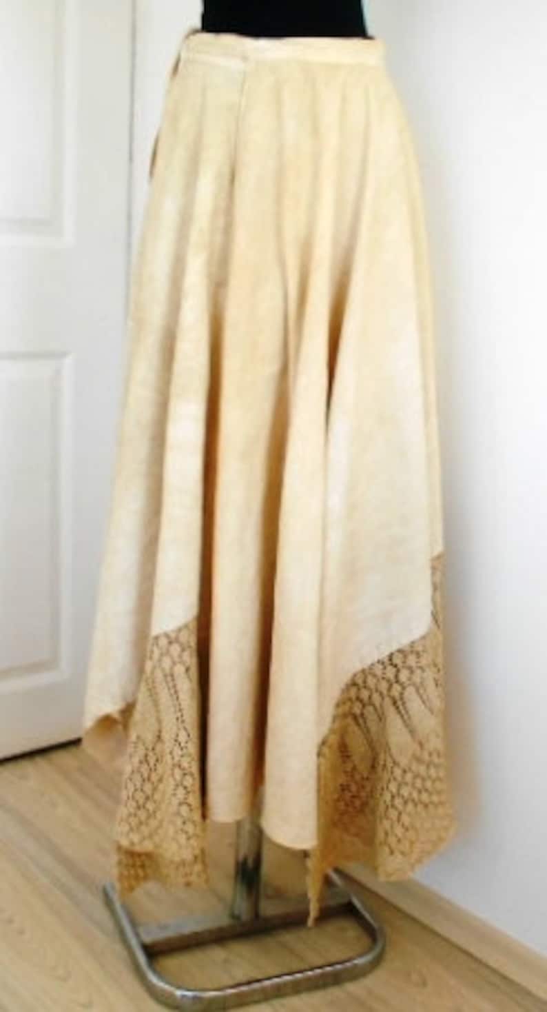May include: A long, cream-colored skirt with a lace trim. The skirt is made of a soft, flowing fabric and has a simple, elegant design.