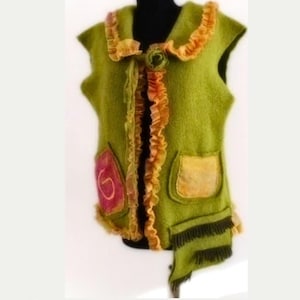 Peut inclure: Un gilet sans manches vert avec un col à volants et des poches. Le gilet a une fleur décorative sur le devant et une frange sur le bas.