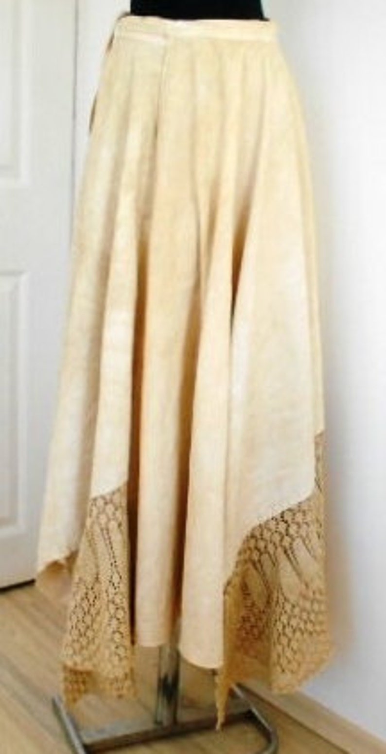May include: A long, cream-colored skirt with a lace trim. The skirt is made of a lightweight fabric and has a flowy silhouette.
