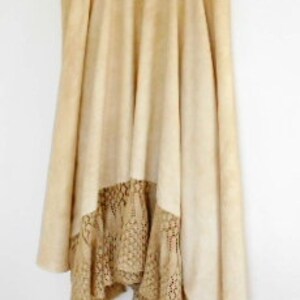 May include: A beige suede skirt with a brown crochet trim. The skirt is a-line and has a slight flare.