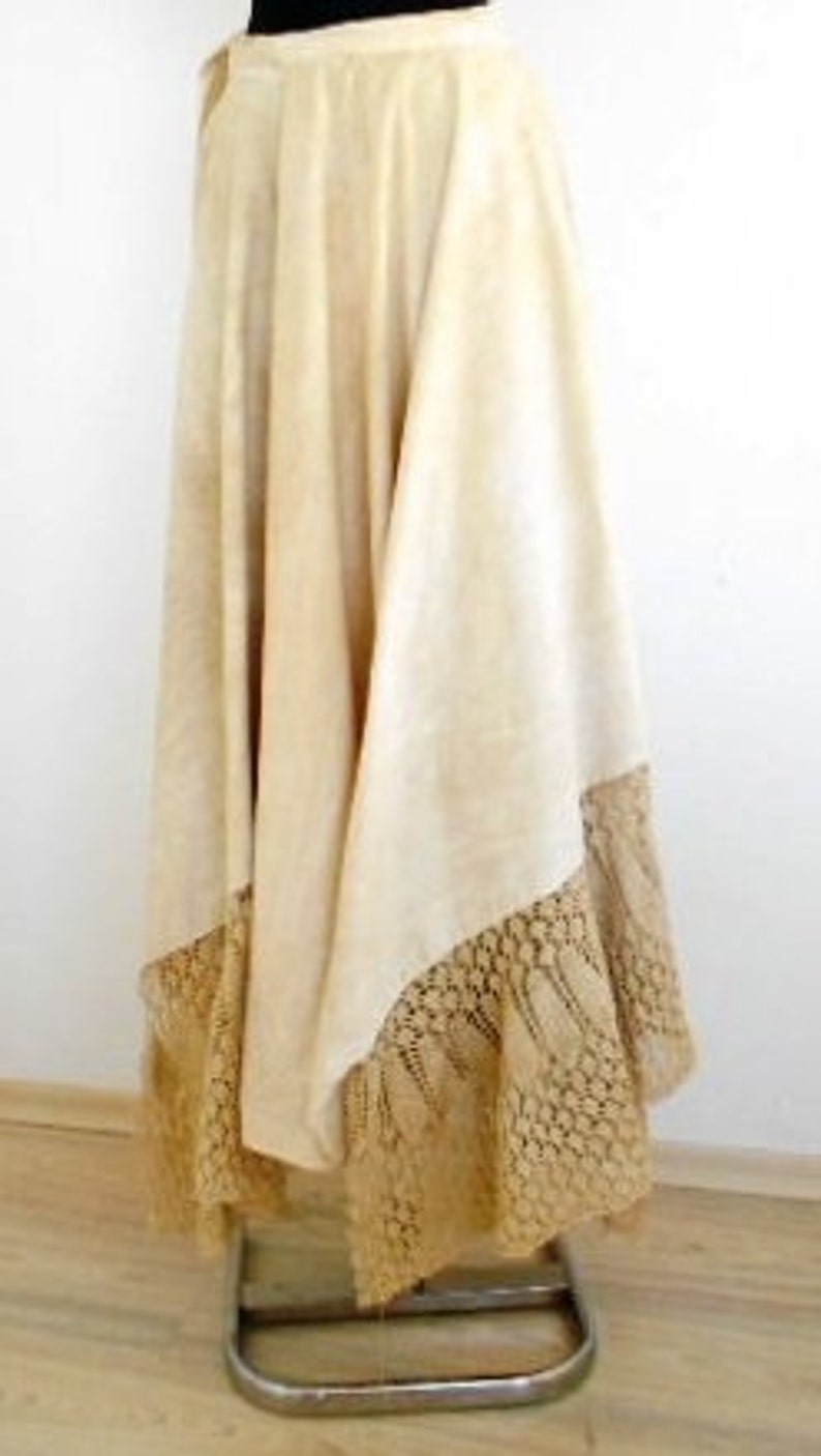May include: A long, white skirt with a lace trim. The skirt is made of a lightweight fabric and has a flowing silhouette.