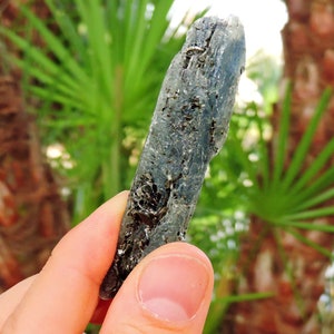 Natural blue kyanite mineral with sparkling mica inclusions, elongated crystal blade.