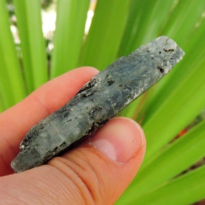 Blue kyanite mineral showing silvery reflections from mica inclusions, natural crystal.