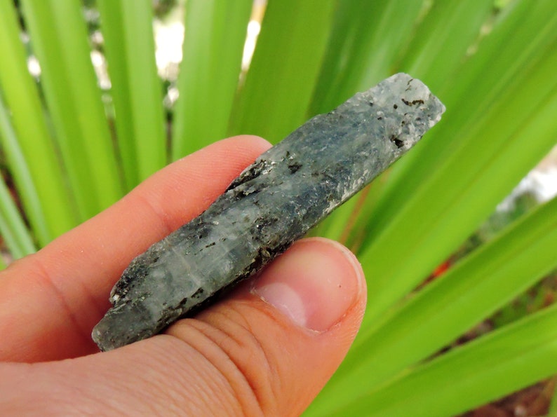 Blue kyanite mineral showing silvery reflections from mica inclusions, natural crystal.