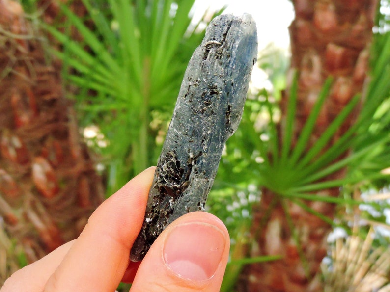 Natural blue kyanite mineral with sparkling mica inclusions, elongated crystal blade.