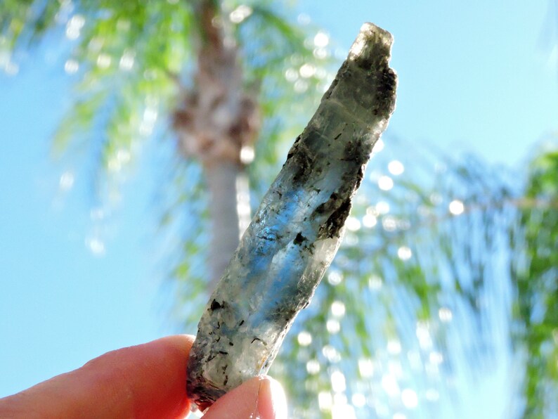 Raw blue kyanite mineral specimen with mica inclusions, highly reflective and natural.