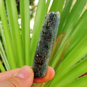 Shiny blue kyanite blade embedded with mica, natural metamorphic mineral.
