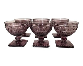 May include: Set of six purple glass dessert dishes with a square base and a fluted design.