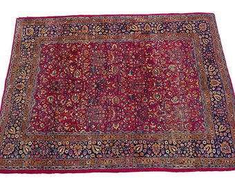 Antique Persian rug with floral design in rust, gold, and navy. Circa 1930. 139"L X104" W