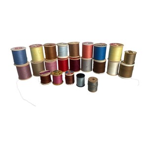 May include: A collection of vintage wooden spools of thread in various colors, including blue, yellow, brown, and pink. The spools are arranged in a group, showcasing the different thread colors and textures. Ideal for sewing and craft projects.