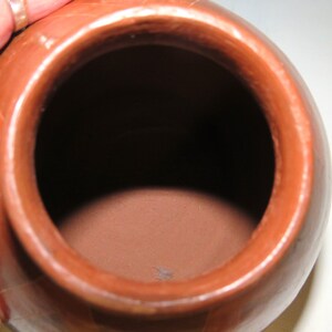 May include: A terracotta pot with a round body and a wide opening. The pot is unglazed and has a natural, earthy finish.