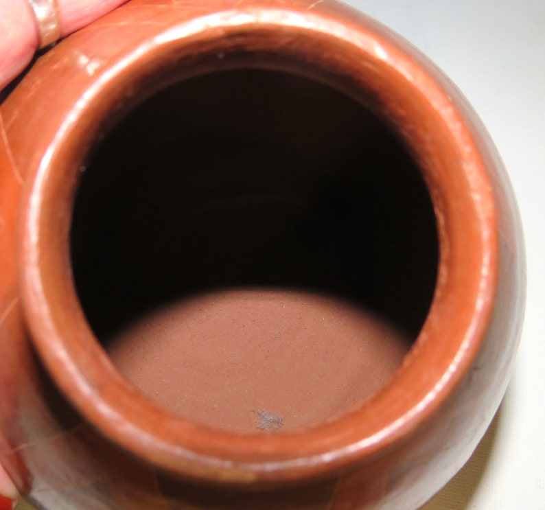 May include: A terracotta pot with a round body and a wide opening. The pot is unglazed and has a natural, earthy finish.