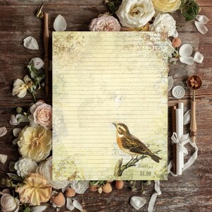 May include: A vintage-style lined stationery sheet with a bird illustration, surrounded by roses and writing supplies. The paper has a faded, aged appearance with a bird perched on a branch. The price tag reads $1.10.