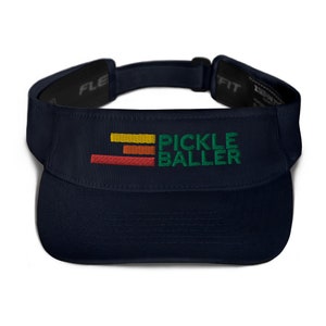 May include: Navy blue visor with the embroidered text "PICKLE BALLER" in green, with a horizontal stripe design in red, orange, and yellow. The visor has a curved brim and an adjustable strap.