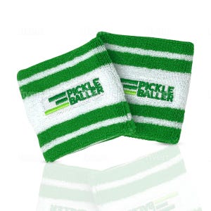 May include: Two white wristbands with green horizontal stripes. The text "PICKLE BALLER" is embroidered in green on each wristband. The wristbands are made of a soft, absorbent material, perfect for pickleball players.