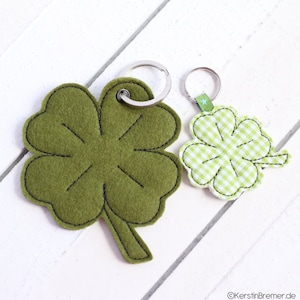 May include: Two green felt four-leaf clover keychains. One is solid green and the other has a white and green checkered pattern.