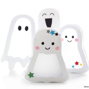Puede incluir: Cuatro adornos blancos con forma de fantasma con diferentes expresiones faciales y detalles de estrellas de colores. Los fantasmas están hechos de un material suave y texturizado y tienen un diseño caprichoso y juguetón.