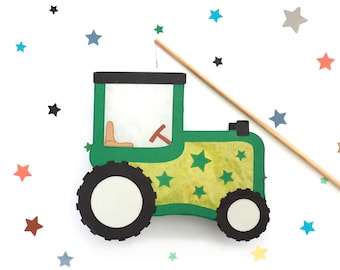 May include: A green and yellow tractor cutout featuring a black roof, black wheels with white centers, a tan seat, and a steering wheel. The tractor body is decorated with green stars and is attached to a thin wooden stick by a single wire.