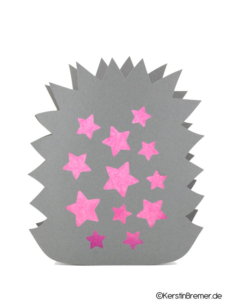 May include: A gray paper cutout in the shape of a hedgehog with jagged edges, featuring multiple pink star-shaped cutouts across its surface. The text KerstinBremer.de is printed in the bottom right corner of the image.