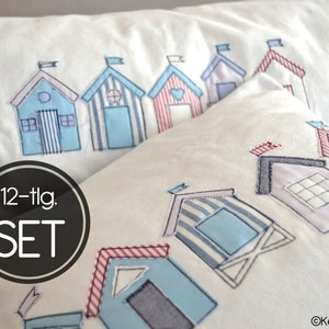 May include: A set of two white pillowcases with blue and red embroidered beach houses. The pillowcases are part of a 12-piece set. The text "12-tlg. SET" is printed on the pillowcases.