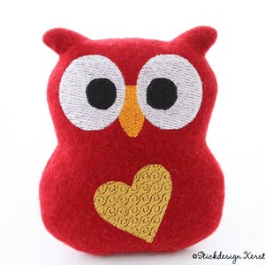 May include: Red felt owl plush toy with embroidered eyes, beak, and a yellow heart on its chest.