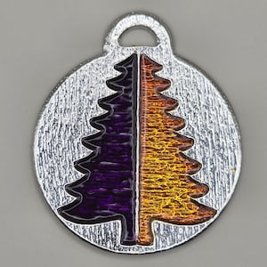 May include: A silver charm with a purple and orange enamel design of a stylized tree. The charm has a loop at the top for attaching to a bracelet or necklace.