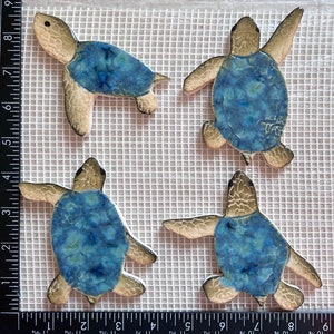 May include: Four ceramic sea turtle tiles with blue and white glaze. The turtles are in various poses, with their heads up and down.