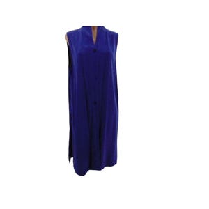 K&ouml;nnte beinhalten: Ein &auml;rmelloses, bodenlanges, kobaltblaues Kleid mit Stehkragen und Knopfleiste vorne. Das Kleid hat eine lockere Passform und Seitenschlitze. Der Stoff scheint ein weiches, flie&szlig;endes Material zu sein.