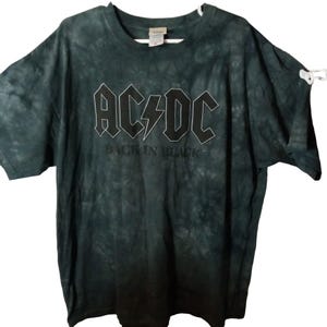 May include: Dark green tie-dye t-shirt featuring the band AC/DC's logo in white, with the text "BACK IN BLACK" below. The shirt has short sleeves and a crew neck.