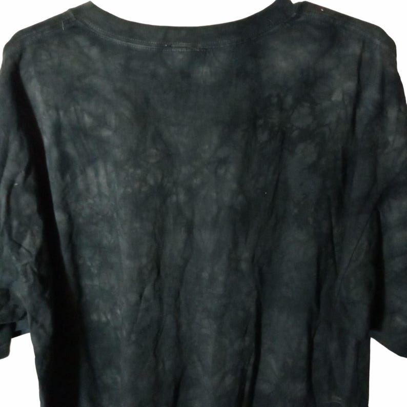 May include: A black t-shirt with a tie-dye pattern. The shirt has a crew neck and short sleeves. The fabric appears soft and slightly faded, with a mottled, dark gray and black design.