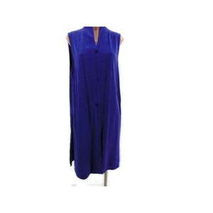 K&ouml;nnte beinhalten: Ein &auml;rmelloses, kobaltblaues Kleid mit V-Ausschnitt und Knopfleiste vorne. Das lange Kleid reicht bis zu den Kn&ouml;cheln und hat Seitenschlitze. Der Stoff scheint ein glattes, flie&szlig;endes Material zu sein.