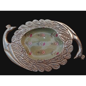May include: A silver-colored peacock-shaped serving dish. The dish features a central oval-shaped bowl with a light green floral pattern. The peacock's body and tail feathers are intricately detailed.