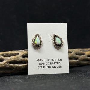 May include: A pair of sterling silver earrings with opal teardrop stones. The earrings are handcrafted and feature a delicate leaf design around the stones. The card reads "Genuine Indian Handcrafted Sterling Silver".