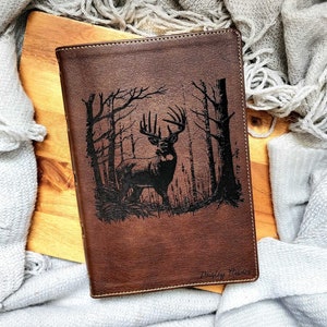 May include: A brown leather journal with a black deer silhouette design and the text "Bradley Harris" embossed on the front.