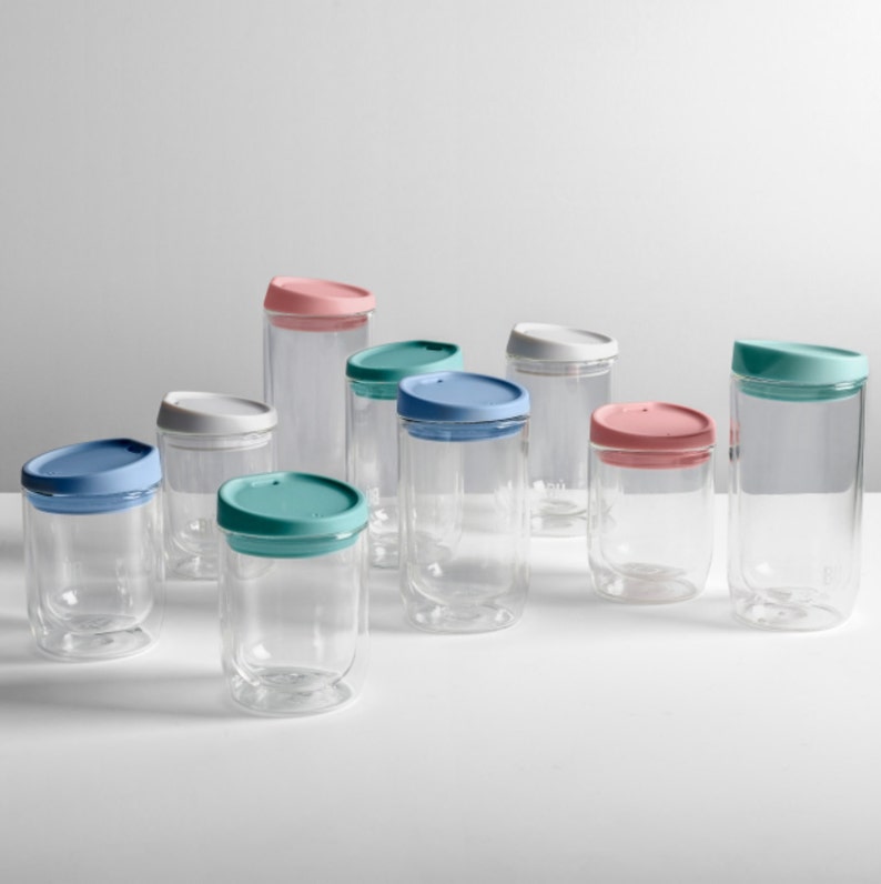May include: A set of nine glass cups with lids in various colours, including blue, green, and pink. The cups are clear glass and have a double-walled design.