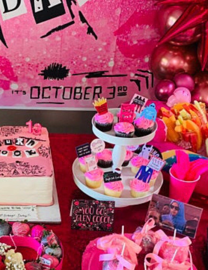 K&ouml;nnte beinhalten: Eine rosa Party-Dekoration mit Kuchen, Cupcakes und verschiedenen Leckereien. Der Kuchen ist mit Text und Zeichnungen verziert. Cupcakes sind mit rosa Zuckerguss und thematischen Dekorationen versehen. Der Hintergrundtext lautet "It's October 3rd".