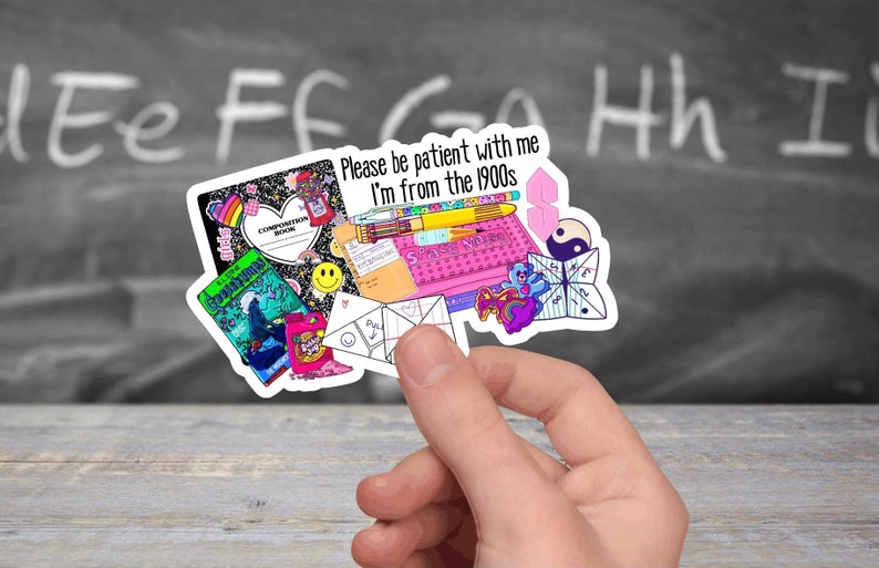 May include: A sticker sheet with a variety of 90s themed images, including a composition book, a pencil, a cassette tape, a game of 'Space Invaders', a paper fortune teller, and a yin yang symbol. The sticker sheet has the text 'Please be patient with me I'm from the 1990s'.