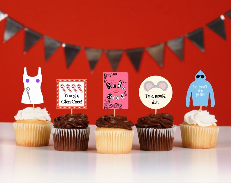K&ouml;nnte beinhalten: F&uuml;nf Cupcakes mit dekorativen Aufs&auml;tzen. Die Aufs&auml;tze zeigen verschiedene Designs, darunter ein wei&szlig;es Kleid mit Schere, Zuckerstangen, den Text "You go, Glen Coco!", ein rosa Buch, M&auml;useohren mit dem Text "I'm a mouse, duh!" und einen blauen Hoodie mit Text.