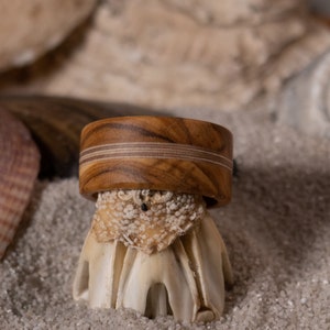 Exceptional ring made of olive wood. Multiple layers of glued birch wood are incorporated in the middle.