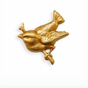 May include: A gold-colored bird brooch with a detailed design, perched on a branch.