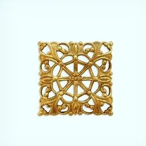 May include: A gold metal decorative square with a detailed intricate design.