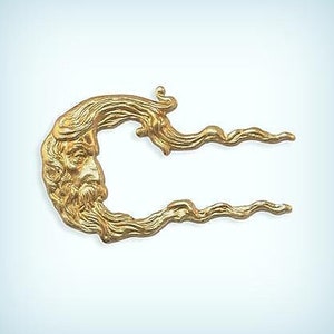 May include: A gold-colored metal ornament shaped like a face with flowing hair and beard. The ornament is in the shape of a letter C with the face on the left side and two flowing tendrils on the right side.
