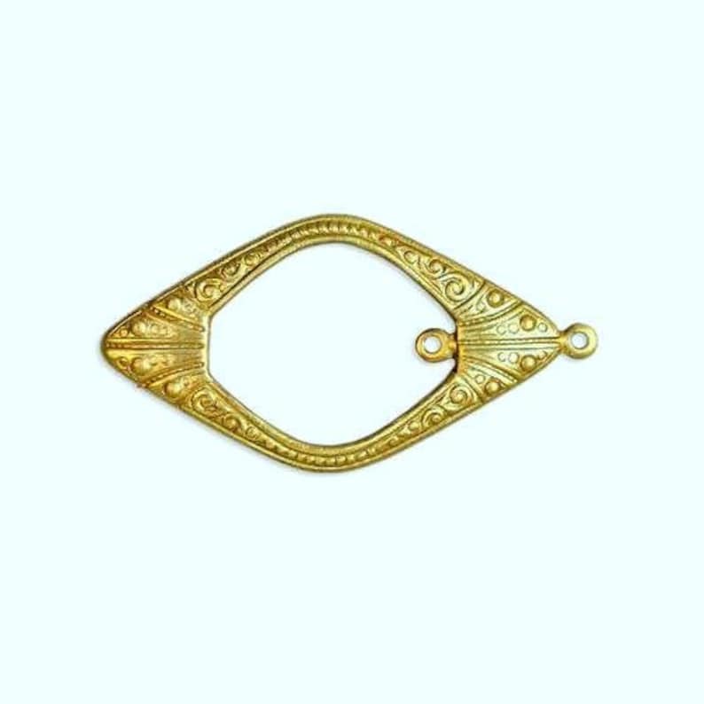 May include: A gold-toned metal connector with an ornate design and two loops. The connector is shaped like a diamond with rounded edges.