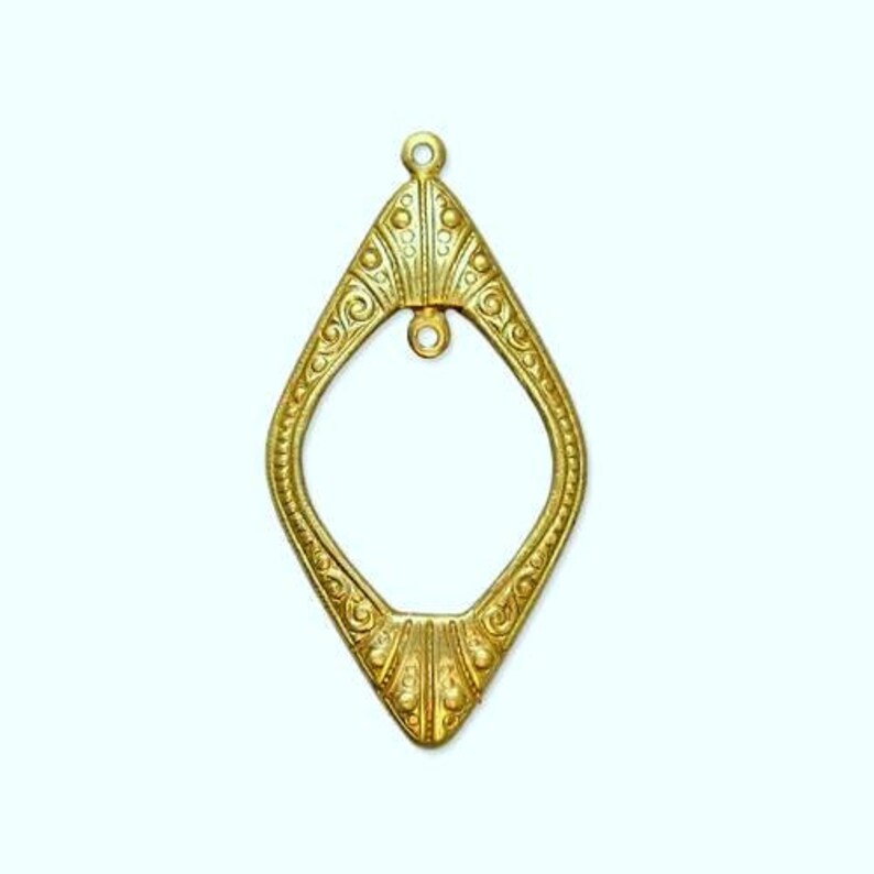 May include: A gold-toned metal pendant with a diamond-shaped frame and intricate details. The pendant has a loop at the top for hanging and a smaller loop at the bottom.
