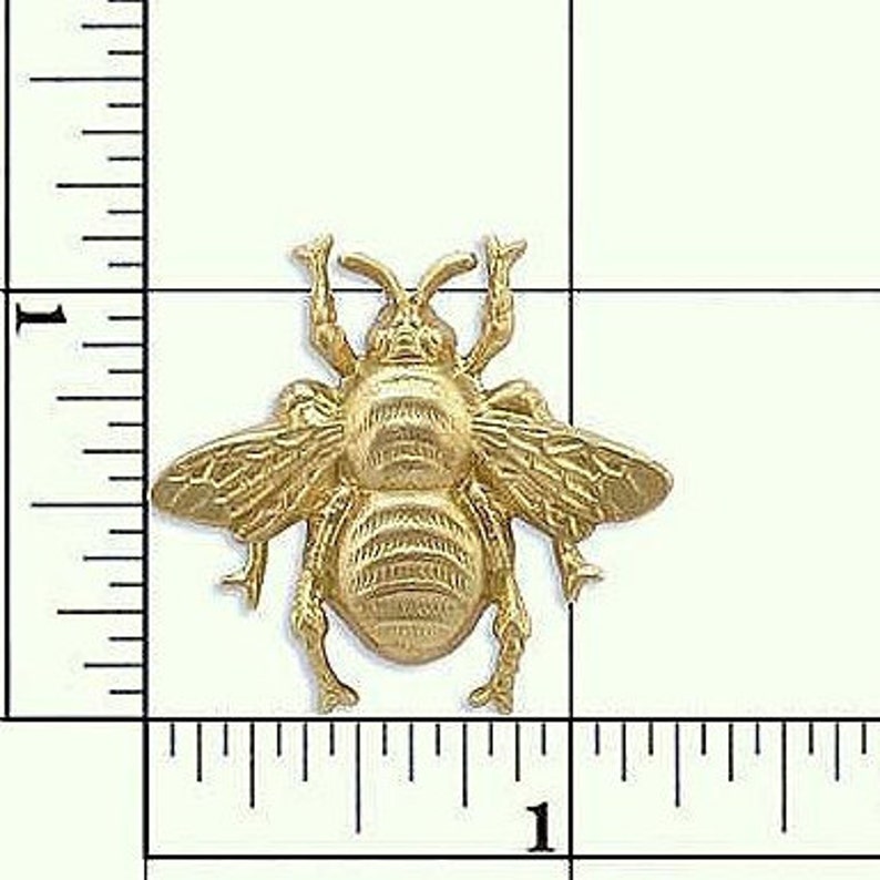 May include: Gold-toned metal bee charm with detailed wings and legs. The bee is approximately 2.5 cm in size.