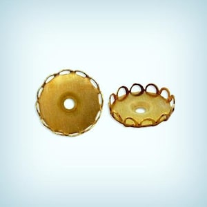 May include: Two gold-colored metal decorative embellishments with a scalloped edge and a hole in the center.
