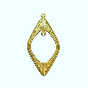 May include: A gold-toned metal pendant with a diamond-shaped frame and intricate details. The pendant has a loop at the top for attaching to a chain or cord.