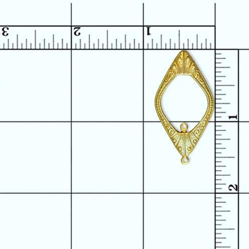 May include: Gold-toned metal pendant with a diamond shape and intricate details. The pendant has two loops at the bottom for attaching a chain or cord.