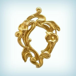 May include: Ornate gold-colored decorative frame with a floral design. The frame features stylized calla lilies and flowing, curved lines. The open center is oval-shaped. The frame is made of a shiny, metallic material.